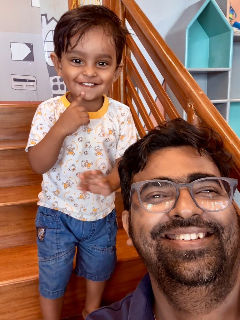 Satyartha smiling on stairs with family